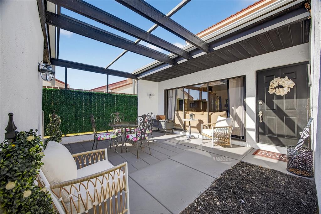 A covered patio features a concrete floor, outdoor furniture, and a black-framed screen enclosure — 5061 SAN ROCCO COURT, PUNTA GORDA, FL