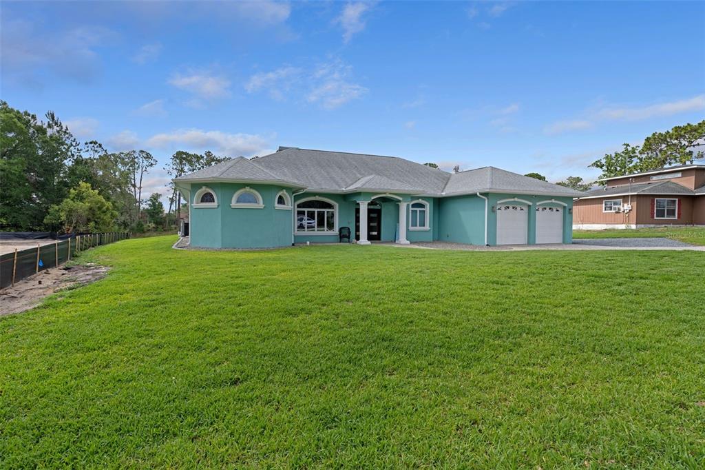 A teal single-story house with a gray roof and a large green lawn — 5050 FREEPORT DRIVE, SPRING HILL, FL