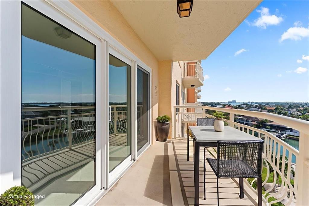 A balcony with a table and chairs overlooks a waterway and residential neighborhood — 4900 BRITTANY DRIVE S UNIT 812, ST PETERSBURG, FL