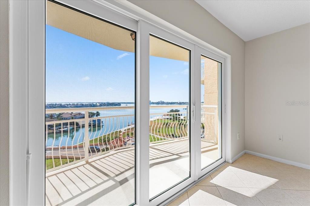 A room with light tile flooring features a large sliding glass door overlooking a balcony — 4900 BRITTANY DRIVE S UNIT 812, ST PETERSBURG, FL