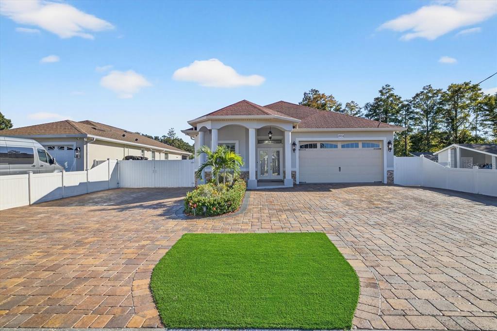 A single-story house with a paved driveway, a small patch of artificial turf, and landscaping — 3914 SLIGH AVENUE, TAMPA, FL