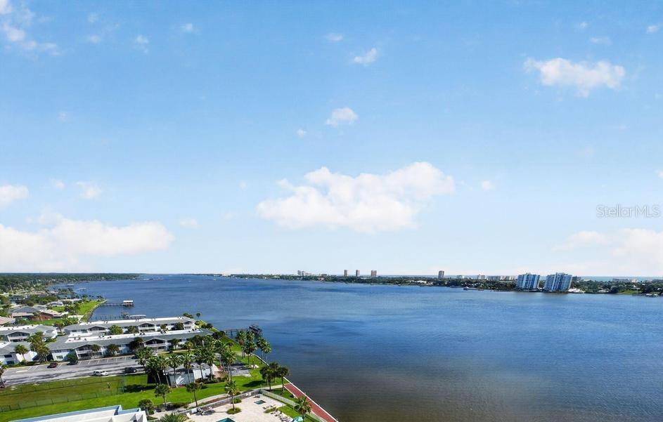 An aerial view of a wide river with residential buildings along the shoreline — 241 RIVERSIDE DRIVE UNIT 1204, HOLLY HILL, FL