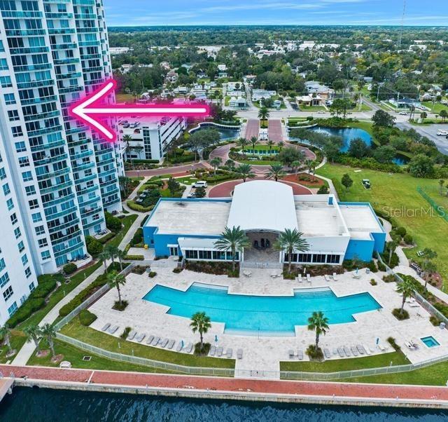 An aerial view shows a tall residential tower next to a pool and clubhouse facility — 241 RIVERSIDE DRIVE UNIT 1204, HOLLY HILL, FL