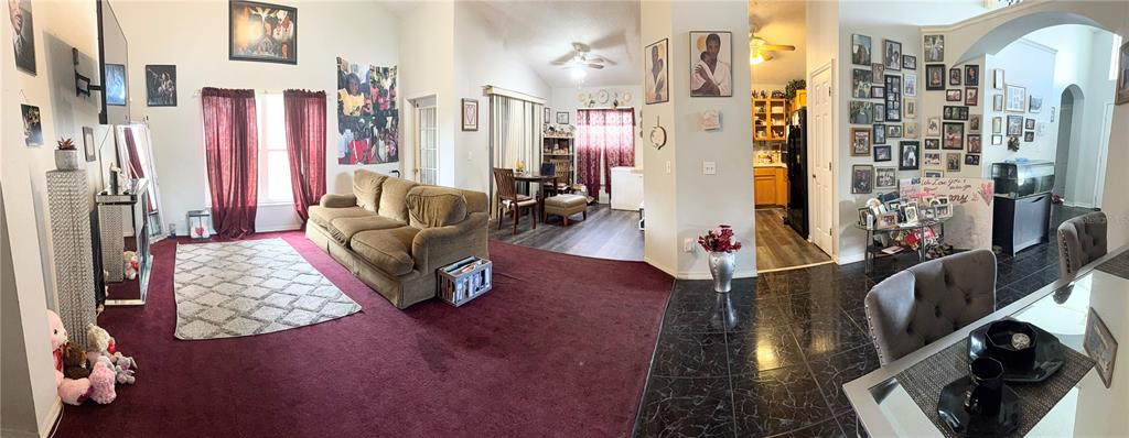A wide-angle view shows a living room with red carpeting, a sofa, and an adjacent dining area — 7031 BLAIR DRIVE, ORLANDO, FL