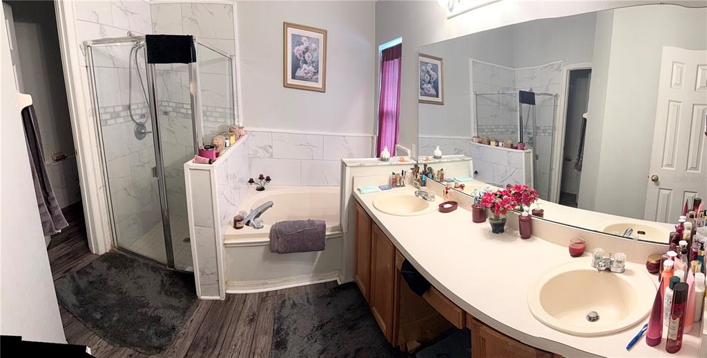 A bathroom features a glass-enclosed shower, a soaking tub, and a double-sink vanity — 7031 BLAIR DRIVE, ORLANDO, FL