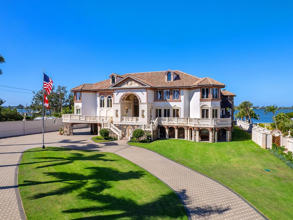 A large, multi-story Mediterranean-style mansion with a paved driveway and waterfront views — 1310 S LAKE SHORE DRIVE, SARASOTA, FL