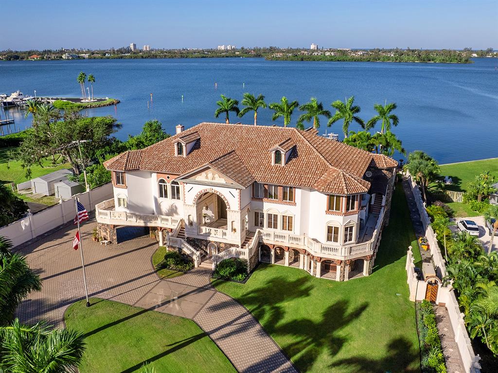 An aerial view of a large waterfront mansion with a tiled roof and paved driveway — 1310 S LAKE SHORE DRIVE, SARASOTA, FL