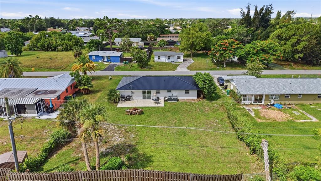 An aerial view shows a single-story house with a dark roof and a backyard patio — 3178 SUNRISE TRAIL, PORT CHARLOTTE, FL