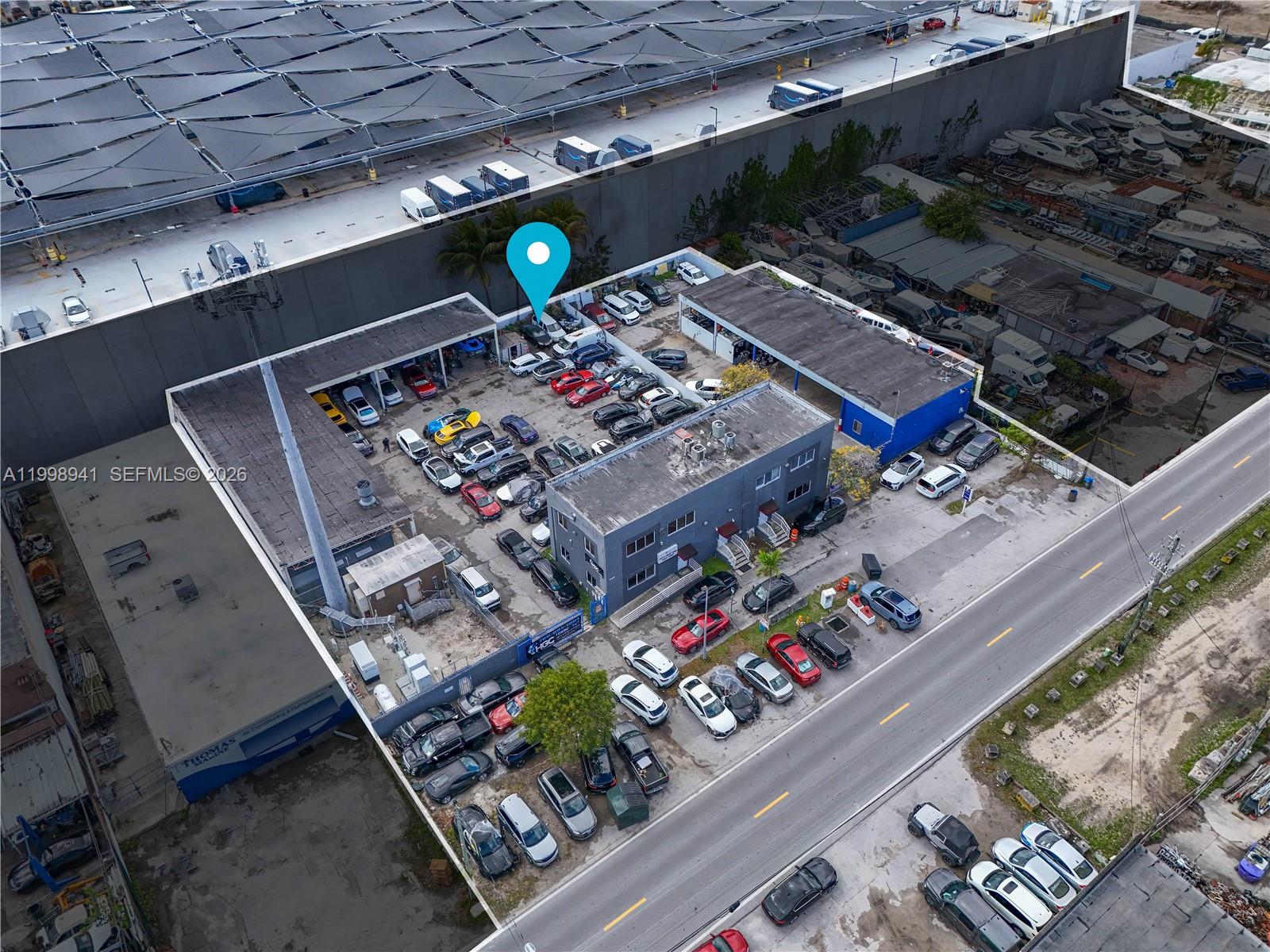 An aerial view shows a commercial property with a parking lot filled with various vehicles — 3326 NW South River Dr, Miami FL 33142, MIAMI, FL