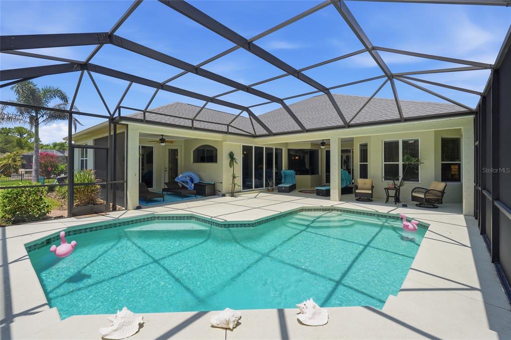 A screened-in patio features a swimming pool, outdoor seating, and a view of the house — 15449 MULHOLLAND ROAD, PARRISH, FL