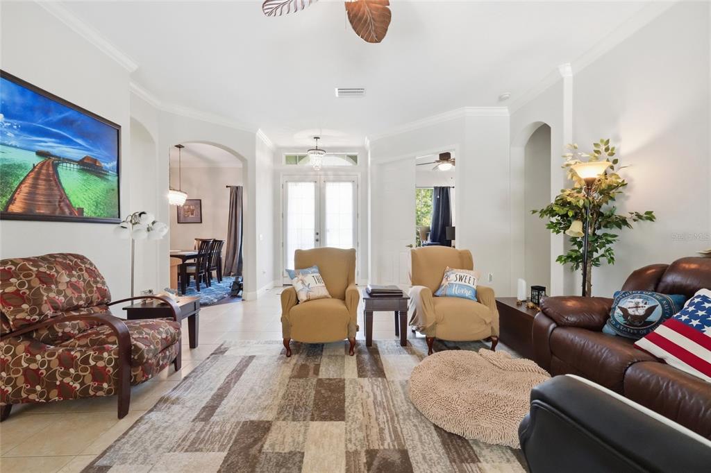 A living room features a patterned armchair, two tan chairs, and a brown leather sofa — 15449 MULHOLLAND ROAD, PARRISH, FL