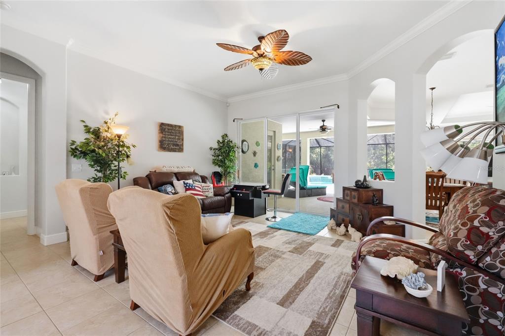 A living room features beige armchairs, a brown sofa, a patterned rug, and a ceiling fan — 15449 MULHOLLAND ROAD, PARRISH, FL