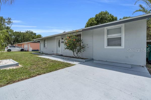 A single-story gray house with a concrete driveway and a small front yard — 18634 GOODMAN CIRCLE, PORT CHARLOTTE, FL