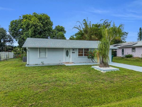 A light gray single-story house with a white front door and a palm tree — 18634 GOODMAN CIRCLE, PORT CHARLOTTE, FL
