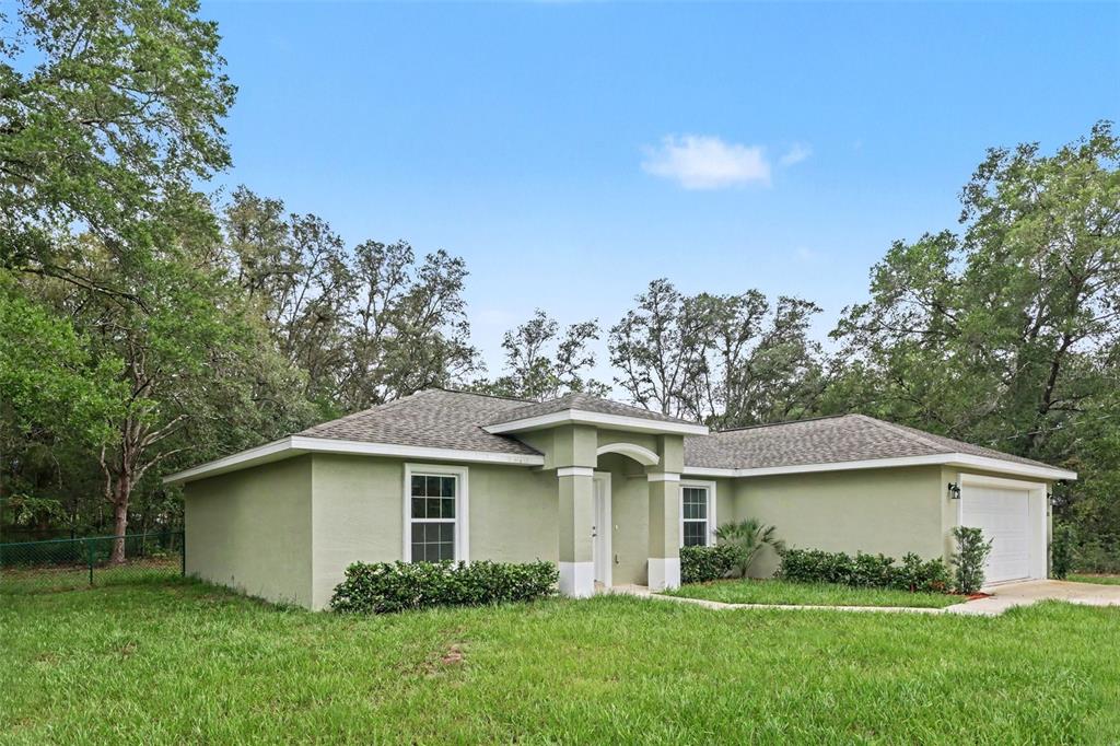 A single-story light green house with a two-car garage and a covered front entryway — 280 W BRIMSON PLACE, CITRUS SPRINGS, FL