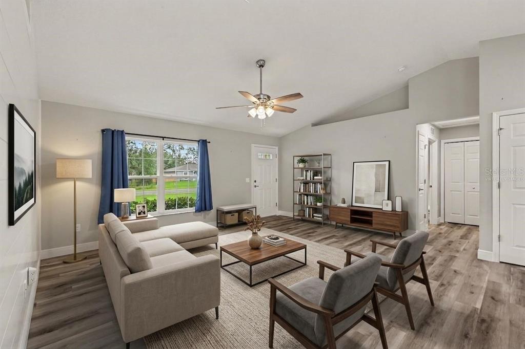 A living room with light gray walls, wood-look flooring, a sectional sofa, and two chairs — 280 W BRIMSON PLACE, CITRUS SPRINGS, FL