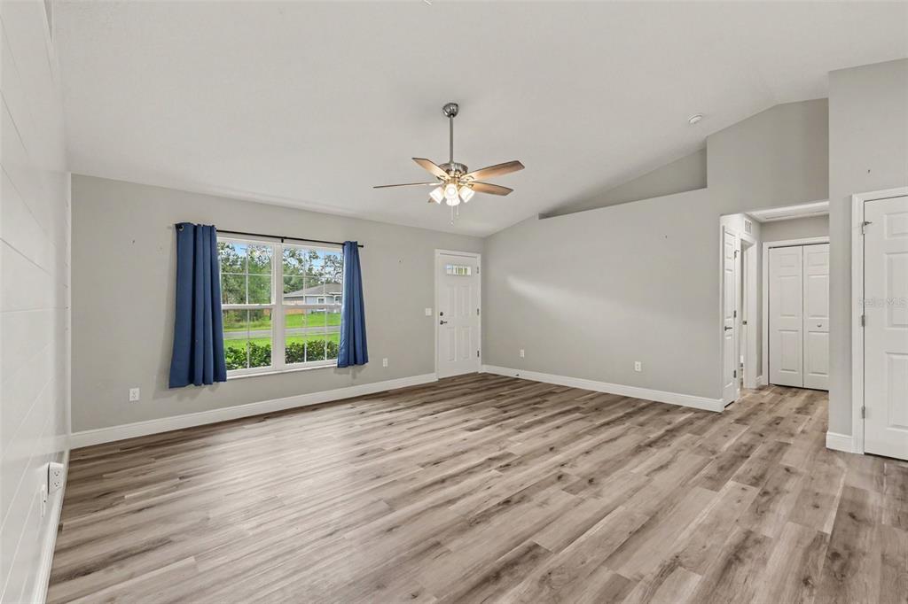 A living room with light gray walls, wood-look flooring, a ceiling fan, and a window — 280 W BRIMSON PLACE, CITRUS SPRINGS, FL
