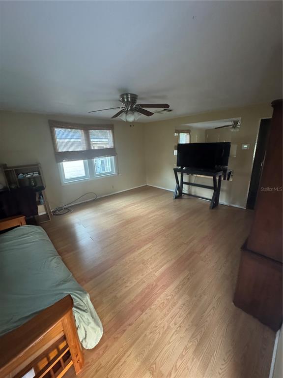 A living room with light wood flooring, a ceiling fan, and a television on a stand — 3845 40TH AVENUE N, ST PETERSBURG, FL
