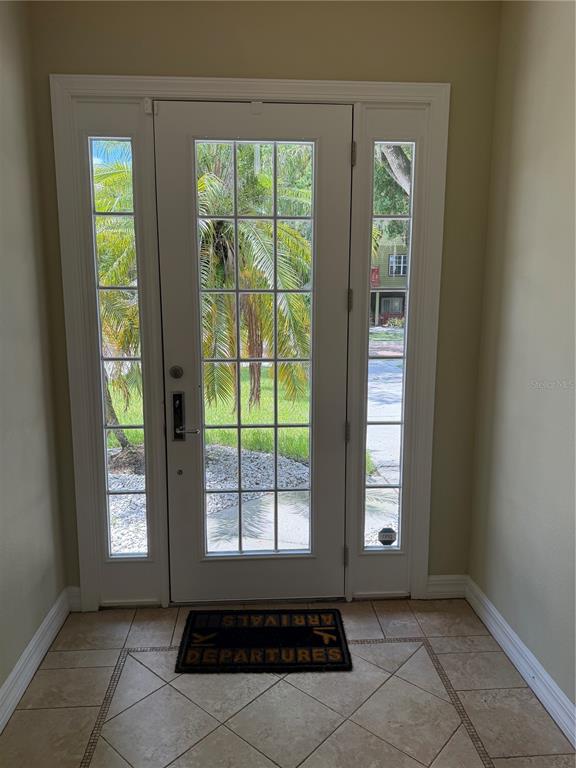 An entryway features a tiled floor, a front door with glass panes, and sidelights — 1009 ELMWOOD STREET UNIT 1009, ORLANDO, FL