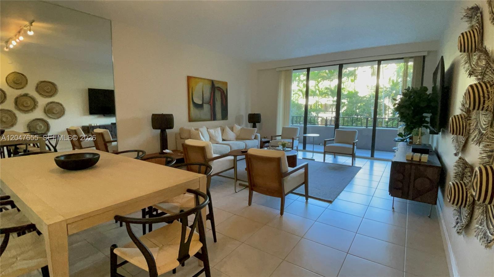 A living and dining area features tile floors, neutral furniture, and large floor-to-ceiling windows — 151 Crandon Blvd # 236, Key Biscayne FL 33149, KEY BISCAYNE, FL