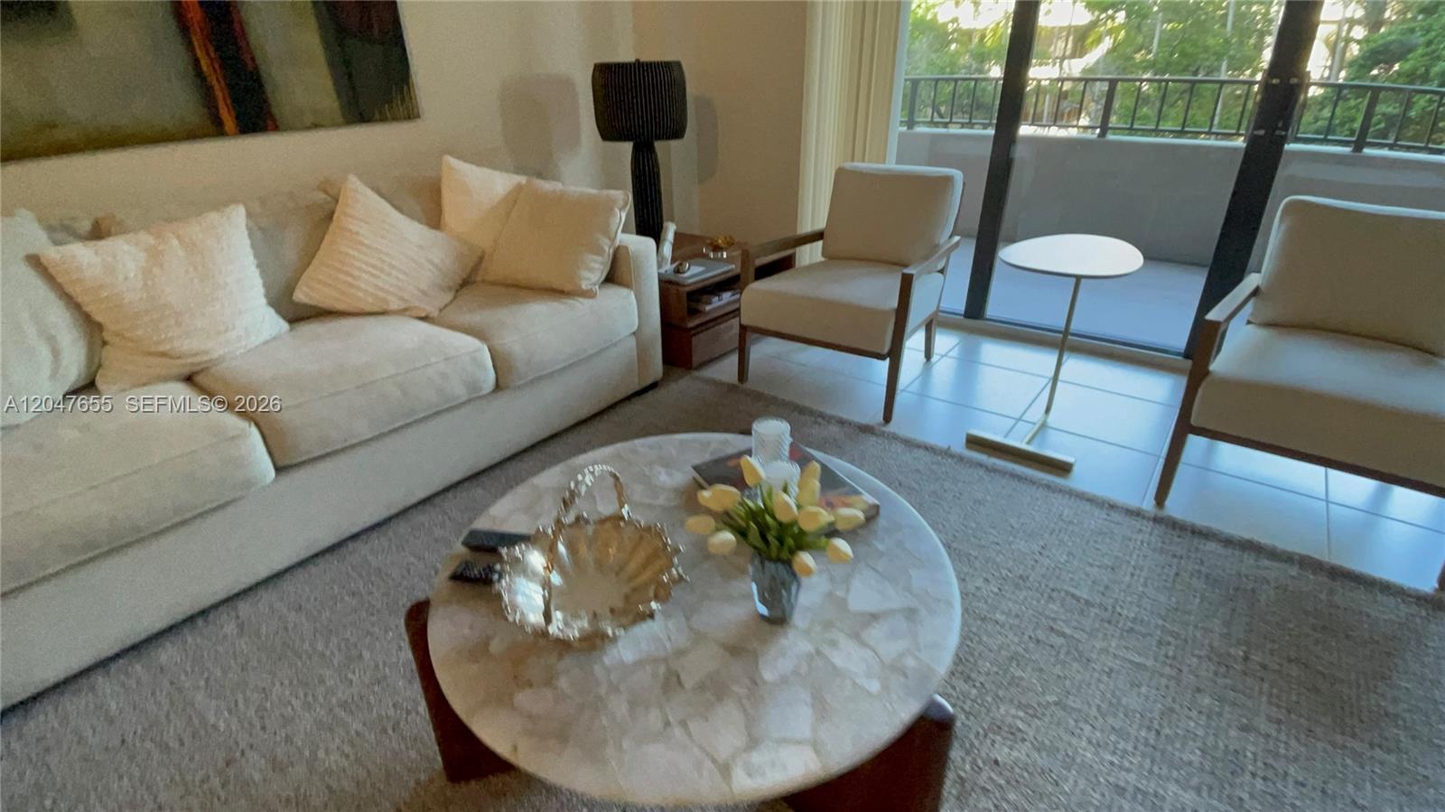 A living room features a beige sofa, two armchairs, and a round stone coffee table — 151 Crandon Blvd # 236, Key Biscayne FL 33149, KEY BISCAYNE, FL