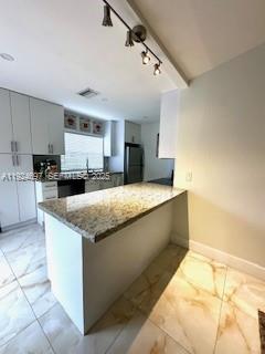 A kitchen features white cabinetry, a granite-topped island, and light-colored tile flooring — 1542 Springside Dr # 1542, Weston FL 33326, WESTON, FL