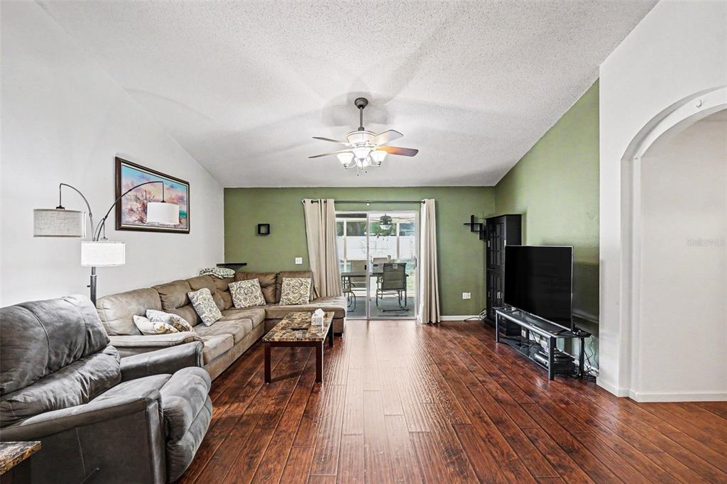 A living room features wood-look flooring, a green accent wall, and a sliding glass door — 531 HEATHER GLEN DRIVE, WINTER HAVEN, FL