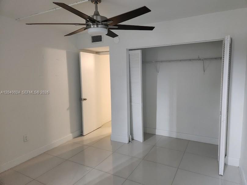 A room with white walls, light tile flooring, a ceiling fan, and a closet — 14185 SW 87th St # A110, Miami FL 33183, MIAMI, FL