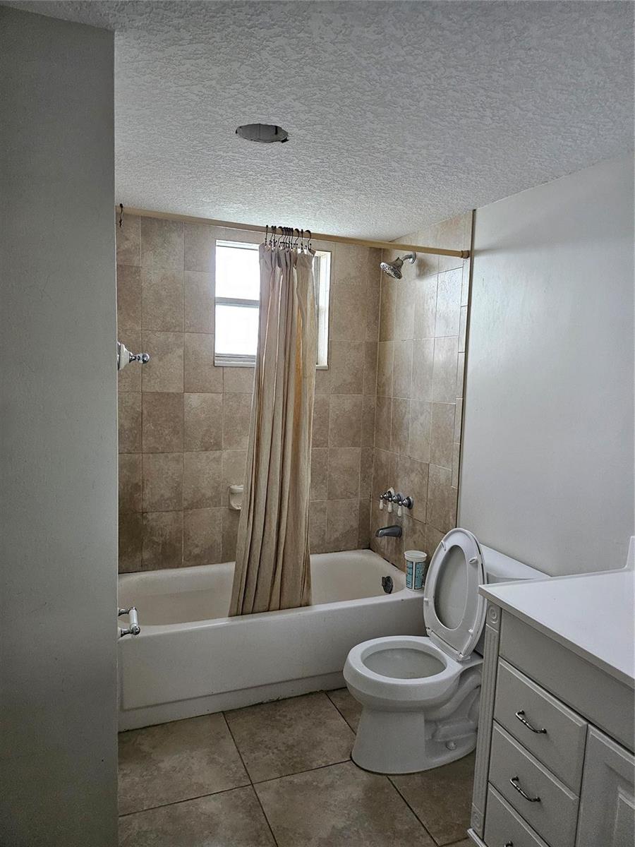 A bathroom features a tiled bathtub shower combination, a white toilet, and a vanity cabinet — 608 NE 2nd Street # 341, Dania Beach FL 33004, DANIA BEACH, FL