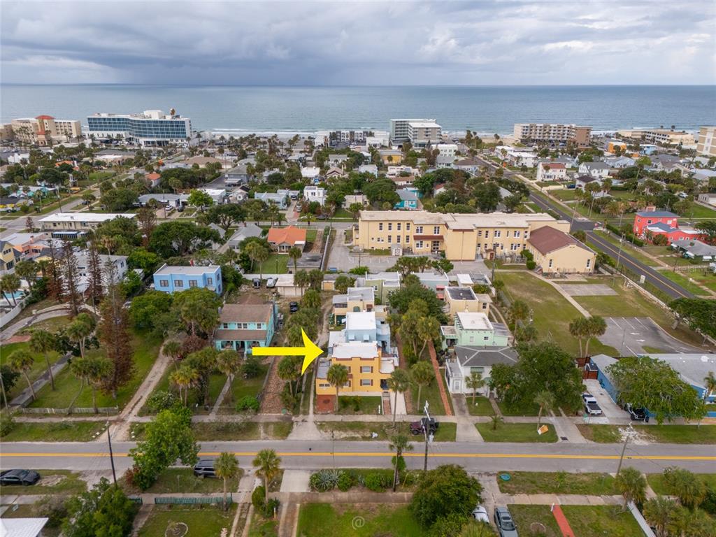 An aerial view shows a yellow multi-story building marked by a yellow arrow — 4 CLARENDON COURT, DAYTONA BEACH, FL