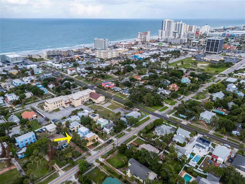 An aerial view shows a coastal neighborhood with a yellow arrow pointing to a house — 4 CLARENDON COURT, DAYTONA BEACH, FL
