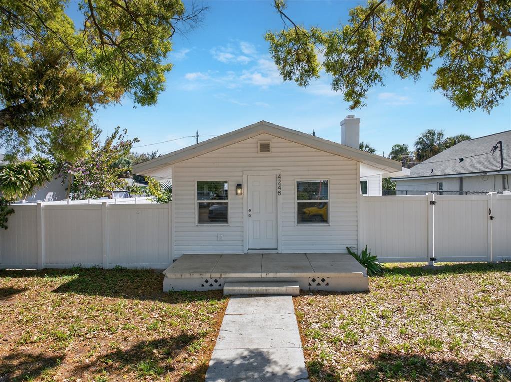 A small, white, single-story house with a front porch and a white vinyl fence — 4248 4TH AVENUE S, ST PETERSBURG, FL