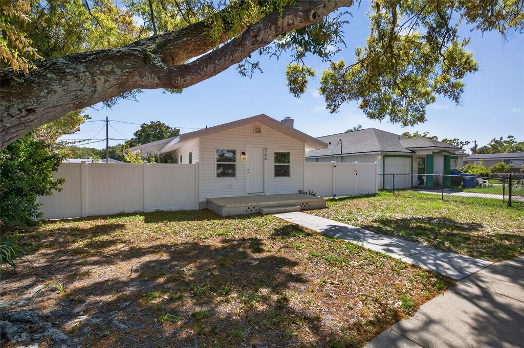 A living room features a black fireplace, blue sofas, a glass coffee table, and light flooring — 4248 4TH AVENUE S, ST PETERSBURG, FL