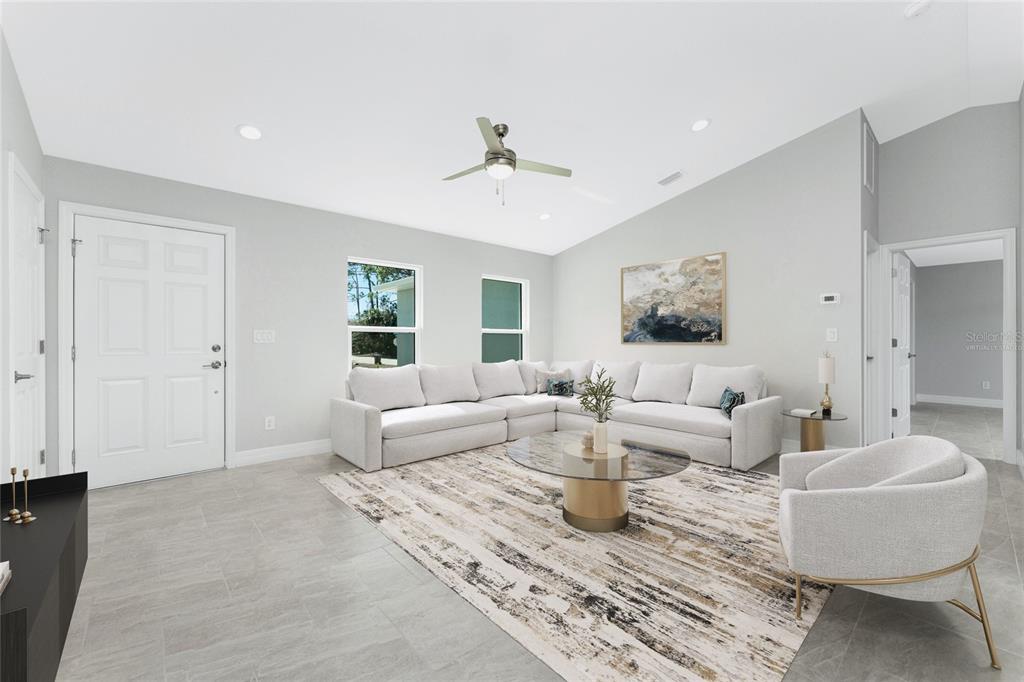 A living room features a large sectional sofa, a glass coffee table, and tile flooring — 3113 VIRGIL STREET, NORTH PORT, FL