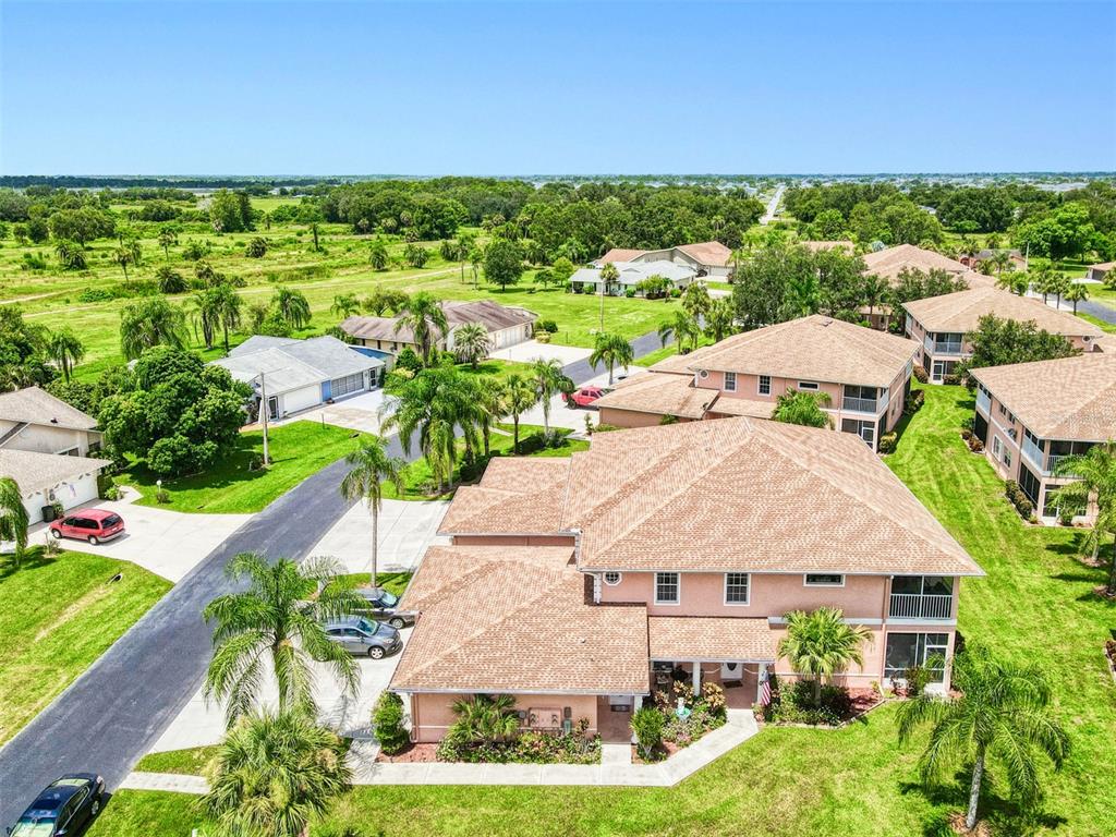 An aerial view shows a two-story suburban house with a tan roof and surrounding landscape — 19977 LAKE VISTA CIRCLE UNIT 17D, LEHIGH ACRES, FL