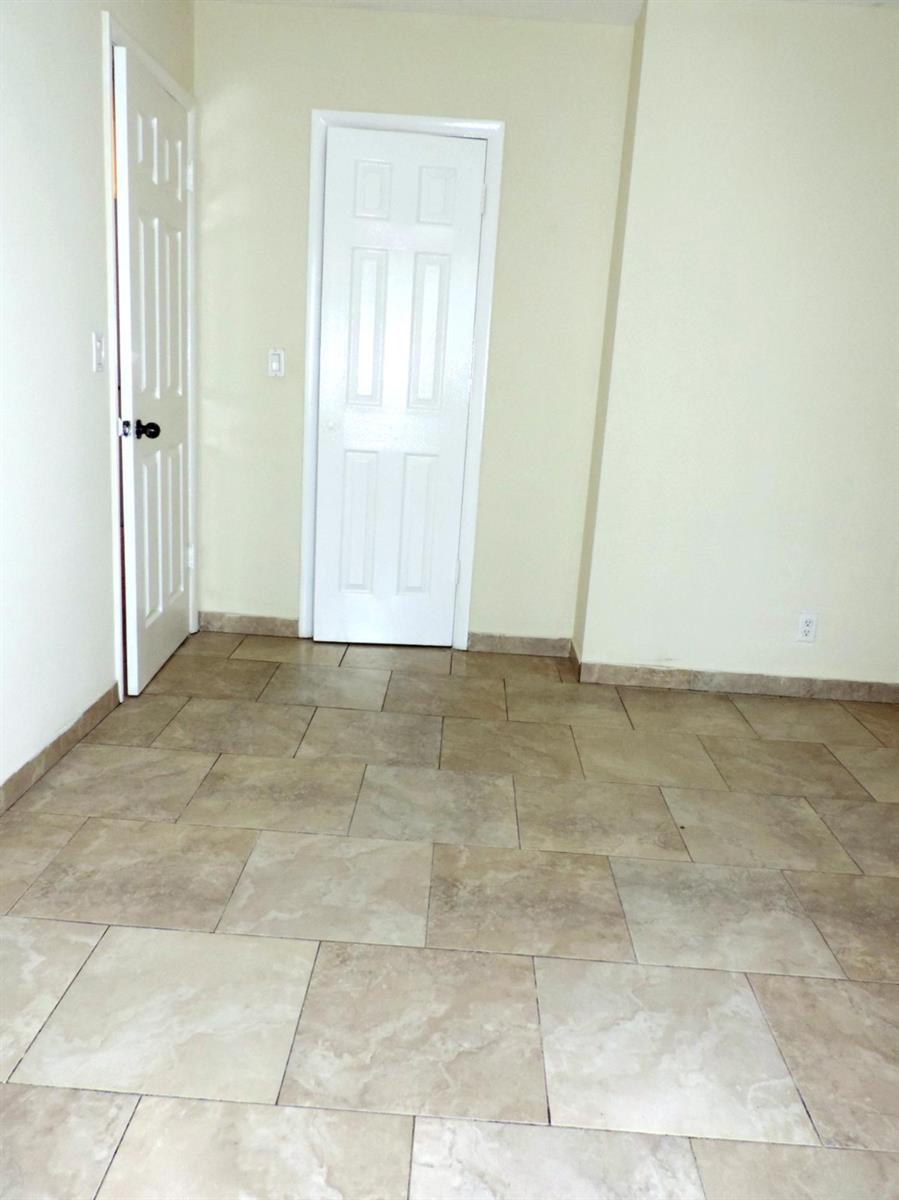 An interior room features beige tile flooring, light-colored walls, and two white paneled doors — 1621 SW 6th Avenue # 2, Pompano Beach FL 33060, POMPANO BEACH, FL