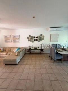 A living room features a sectional sofa, a media console, and a dining area — 1 HARBOUR LAKES UNIT 53, HUMACAO, PR