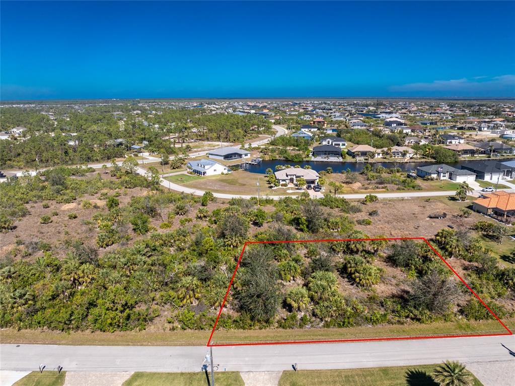 An aerial view shows a vacant, rectangular lot outlined in red along a paved road — 15453 and 15461 ALSASK CIRCLE, PORT CHARLOTTE, FL