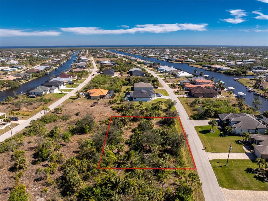 An aerial view shows a vacant, rectangular lot outlined in red along a residential street — 15453 and 15461 ALSASK CIRCLE, PORT CHARLOTTE, FL