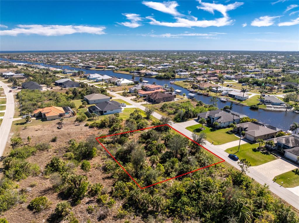 An aerial view shows a vacant, rectangular lot outlined in red within a residential neighborhood — 15453 and 15461 ALSASK CIRCLE, PORT CHARLOTTE, FL