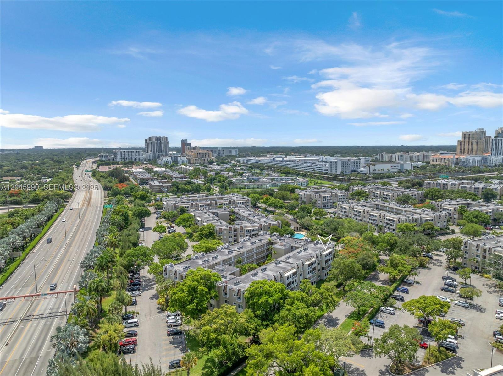An aerial view shows a multi-story apartment complex surrounded by trees and parking lots — 8101 Camino Real # 402, Miami FL 33143, MIAMI, FL