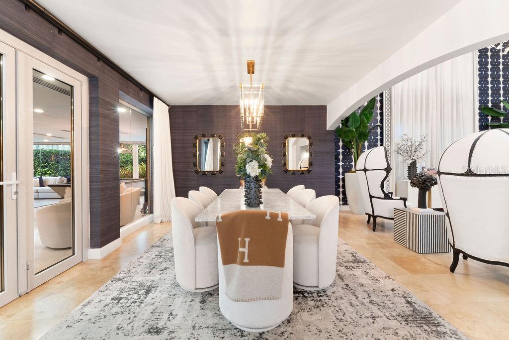 A dining room features a marble table, white chairs, a patterned rug, and dark wallpaper — 386 DORADO BEACH EAST, DORADO, PR