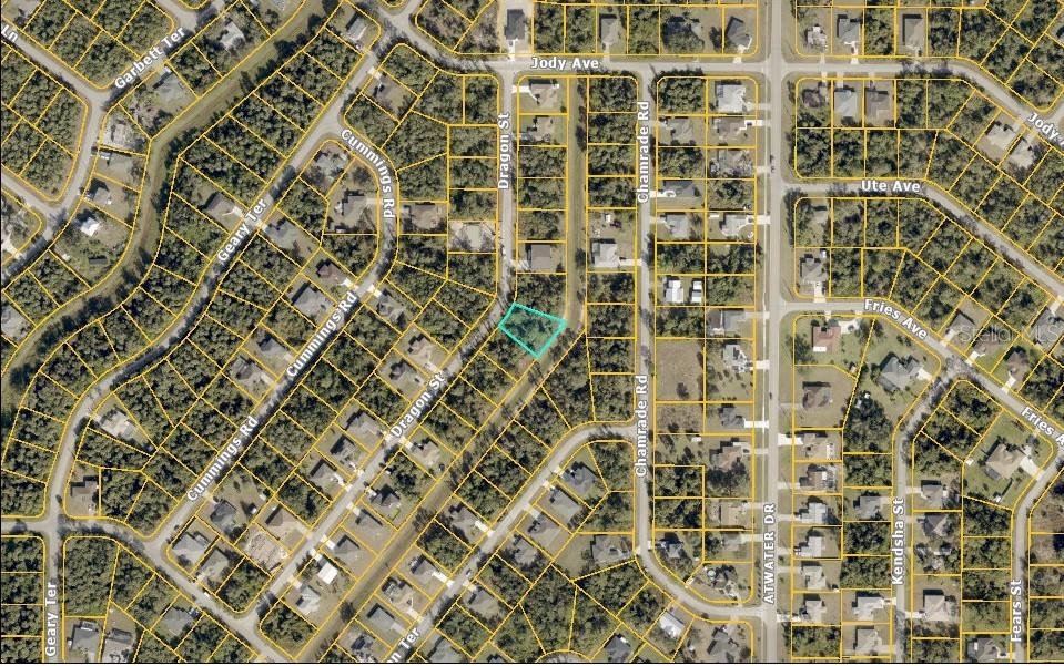 This is an aerial map showing a vacant lot highlighted in blue within a residential neighborhood — DRAGON STREET, NORTH PORT, FL