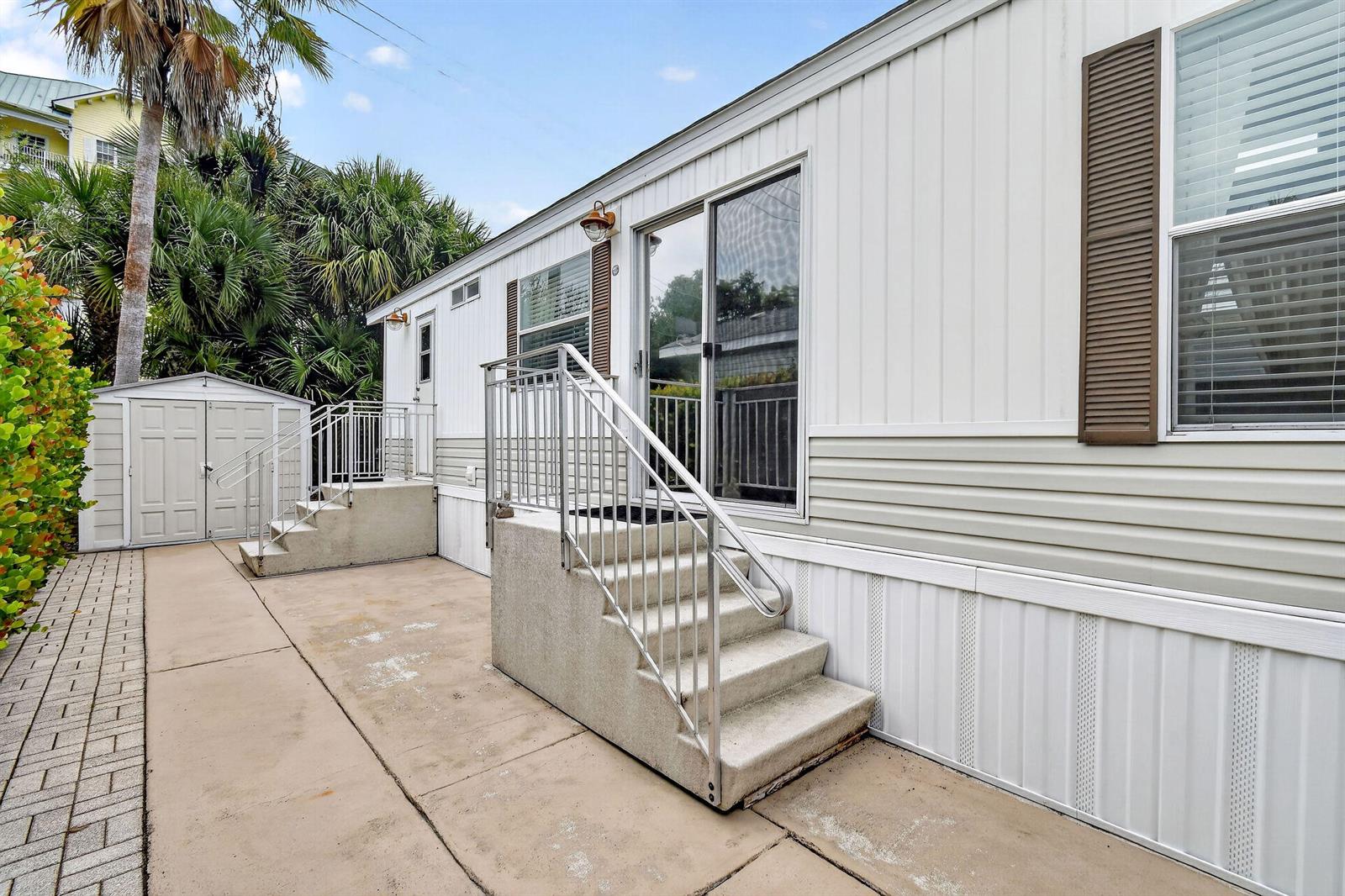 The exterior of a mobile home features two sets of concrete steps with metal railings — 900 Juno Ocean Walk # 2, Juno Beach FL 33408, JUNO BEACH, FL