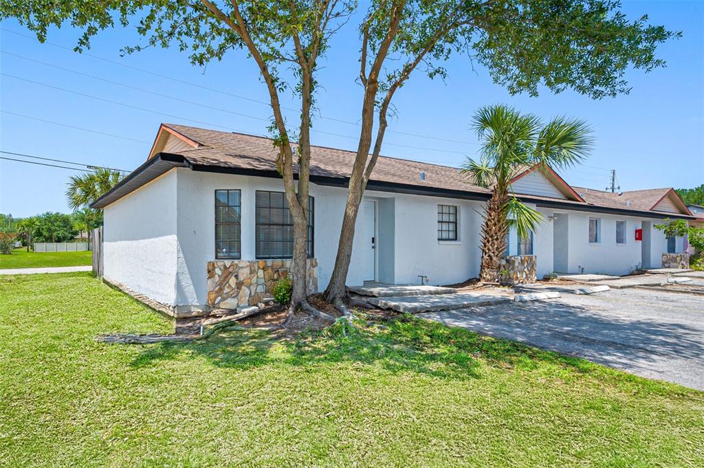 A single-story white building with stone accents, a shingled roof, and a palm tree — 501 ST. MICHAELS WAY UNIT 517, TARPON SPRINGS, FL