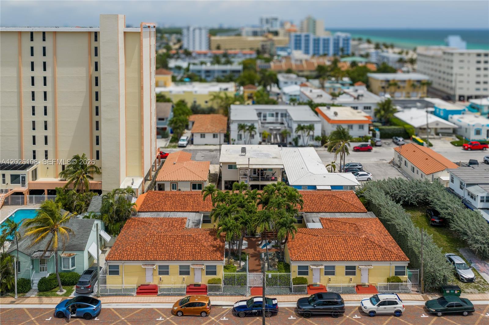 An aerial view shows a yellow apartment complex with red tile roofs and palm trees — 335 Georgia St, Hollywood FL 33019, HOLLYWOOD, FL