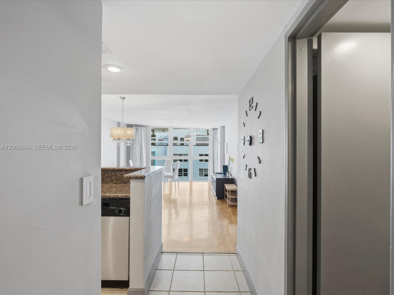 A view from a tiled entryway into a living area with wood flooring and windows — 1228 West Ave # 1506, Miami Beach FL 33139, MIAMI BEACH, FL