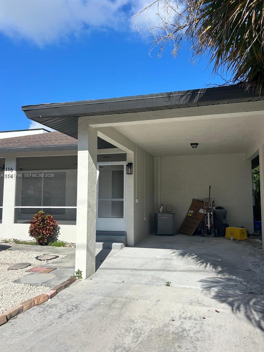 An open-concept kitchen with granite countertops and white cabinets flows into a living area — 114 S Lakeside Dr # 114, Lake Worth FL 33460, LAKE WORTH, FL