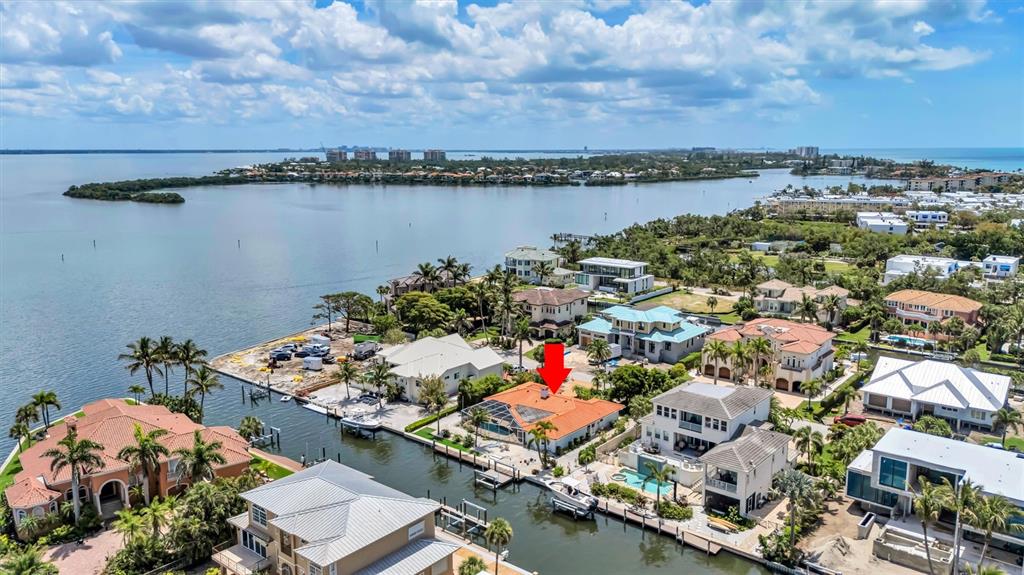 An aerial view shows a waterfront house with a red-tiled roof and a boat dock — 617 ROUNTREE DRIVE, LONGBOAT KEY, FL