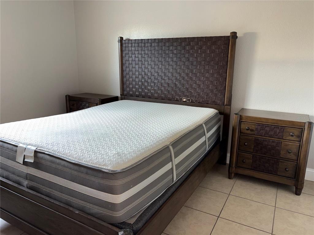 A bedroom features a woven-texture headboard, a mattress on a wooden frame, and two nightstands — 5822 CONGRESS STREET UNIT 104, NEW PORT RICHEY, FL